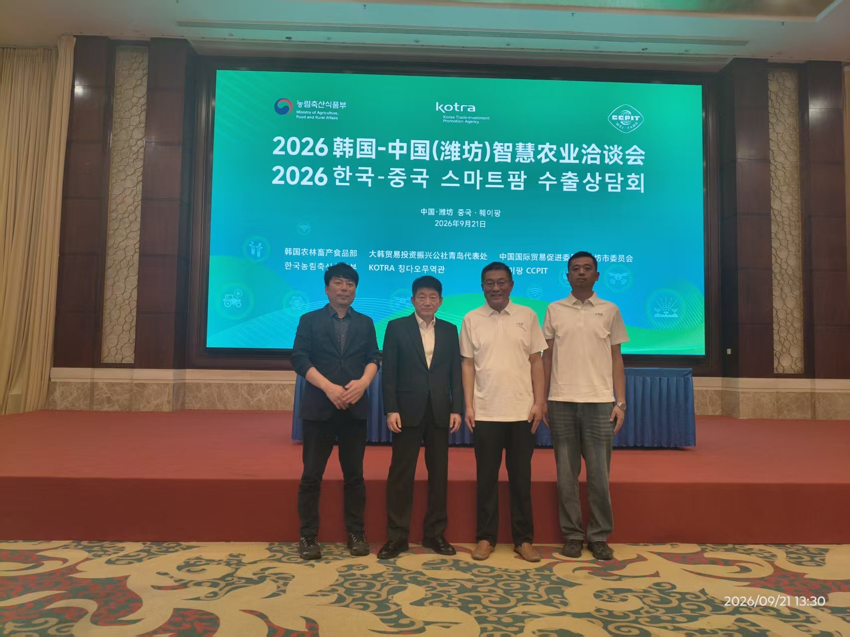 与会代表在洽谈会主背景板前合影